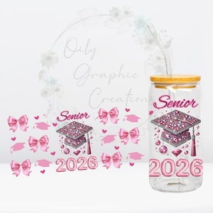 May include: A clear glass tumbler with a bamboo lid and a straw. The tumbler is decorated with pink graduation caps, bows, hearts, and the words "Senior 2026". The graduation cap design is embellished with pink rhinestones.