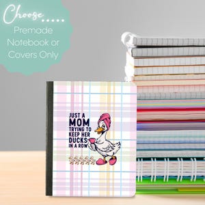 Pode incluir: Caderno com capa xadrez em tons pastel, apresentando um pato de desenho animado com uma toalha rosa e segurando uma xícara. O texto diz "Just a Mom tentando manter seus patos em fila."
