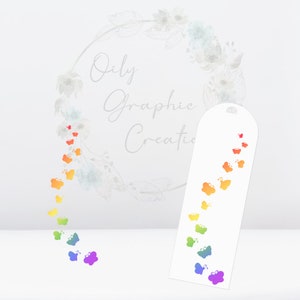 Op de afbeelding: Een witte bladwijzer met een regenboog van vlinders die omhoog vliegen. De bladwijzer is langwerpig met afgeronde hoeken. De tekst "Oily Graphic Creations" is zichtbaar op de achtergrond.