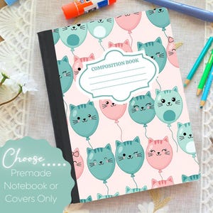 May include: A composition book with a pink cover featuring a pattern of cat-shaped balloons in teal and pink. The cover has the words "COMPOSITION BOOK" and a blank label. The notebook is black and has a white lace background.