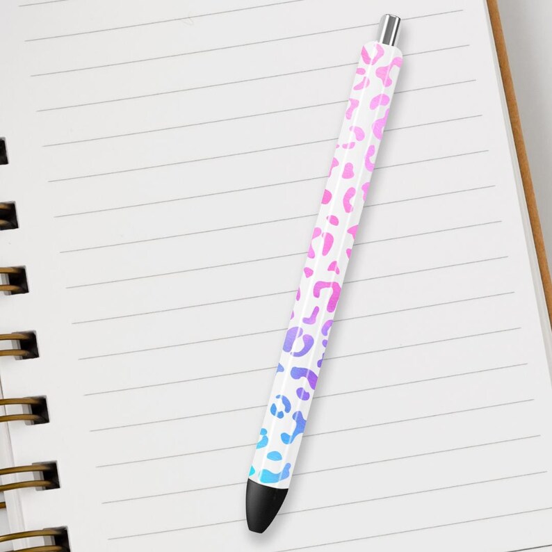 May include: A white pen with a pink and blue ombre leopard print design.