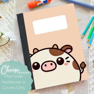 May include: A notebook with a light peach cover featuring a cartoon cow design. The cow has brown spots and a pink nose. The notebook has a black spine and a white label area. Text on the image reads "Choose... Premade Notebook or Covers Only."