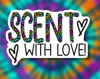 May include: A white sticker with the word "SCENT" in black letters with a leopard print pattern. The word "WITH LOVE!" is below the word "SCENT" in black letters. There are two hearts on the sticker.