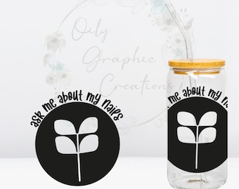 May include: A clear glass tumbler with a bamboo lid and a silver straw. The tumbler features a black circular design with a white plant graphic and the text "ask me about my nails". A matching design is on a separate black circle.
