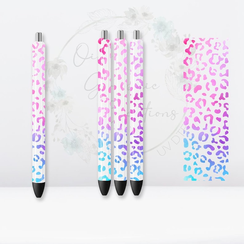 May include: Four white pens with a pink, purple, and blue ombre leopard print design.
