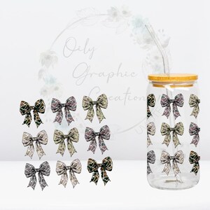 May include: A clear glass tumbler with a bamboo lid and a straw. The tumbler is decorated with a pattern of camouflage-colored bows.