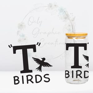 Puede incluir: Un tarro de vidrio transparente con tapa de bambú y una calcomanía de vinilo negro que dice "T Birds" con una silueta de pájaro. El tarro tiene una pajita que sobresale de la tapa.