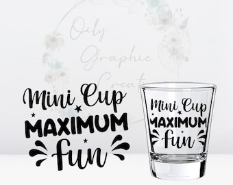 May include: A clear glass shot glass with the text "Mini Cup Maximum Fun" printed on it in black. The text is surrounded by small stars and a design of fireworks.