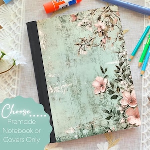 May include: A notebook with a floral design. The cover has a distressed, light blue background with pink flowers and green leaves. The text "Choose... Premade Notebook or Covers Only" is on the bottom left.