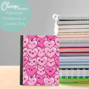 Puede incluir: Un cuaderno con una cubierta con un patrón de corazones rosas de dibujos animados con caras sonrientes. El texto "Choose... Premade Notebook or Covers Only" está en la esquina superior izquierda. Una pila de cuadernos está en el fondo.