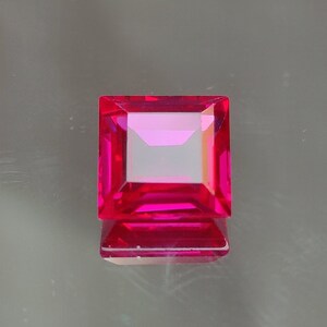 Può includere: Una gemma quadrata di colore rosa vibrante con taglio a faccette.