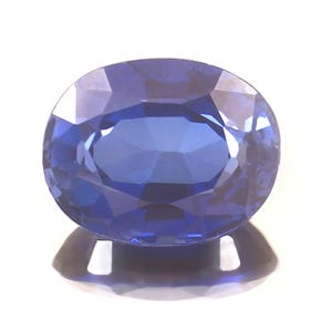 May include: A deep blue oval sapphire gemstone with a faceted cut.