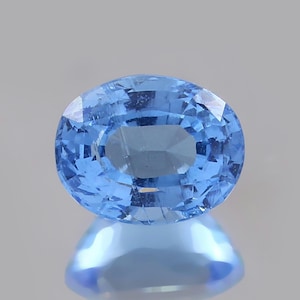 May include: A light blue oval-shaped gemstone with a faceted cut.