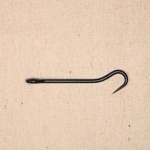 May include: A black metal hook with a curved end. The hook is about 10 inches long.