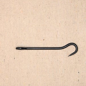 May include: A black metal hook with a rounded end and a sharp point. The hook is bent into a curved shape.
