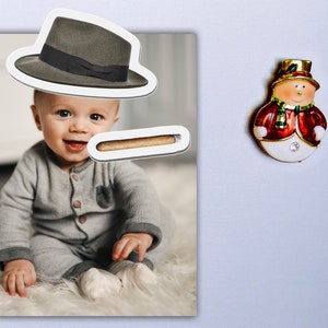 May include: A photo of a baby wearing a grey onesie and a fedora hat. A brown cigar is placed above the baby's mouth.