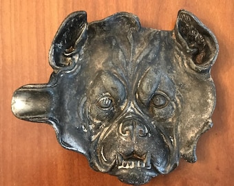Posacenere vintage in ghisa con bulldog, figura a rilievo di testa di cane con denti ringhianti.