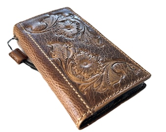 May include: A brown leather wallet with a floral embossed design. The wallet has a snap closure and a loop for a key chain.