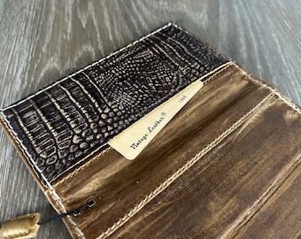 May include: A brown leather wallet with a crocodile embossed pattern and a label that reads "Vintage Leather - 1948".