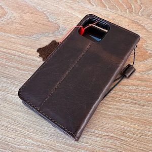 A brown leather wallet is placed on a wooden surface.