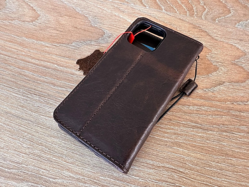A brown leather wallet is placed on a wooden surface.