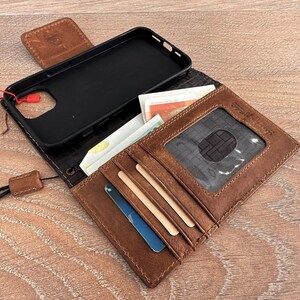 a brown wallet with a black case inside, placed on a wooden surface.