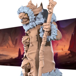 May include: A detailed figurine of a fantasy creature with a bone-like face, yellow eyes, and a light blue fur-trimmed coat. The figure holds a wooden staff with bells. The creature has multiple faces emerging from its coat.