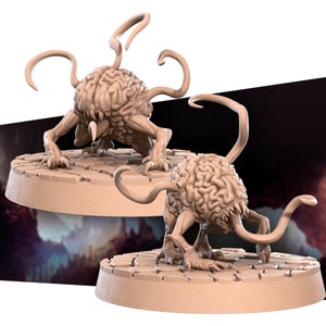 May include: Two 3D printed miniature brain-like creatures with multiple tentacles, standing on circular bases with a textured surface.