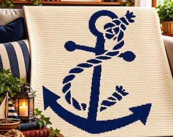 May include: A cream-colored crocheted blanket featuring a large, centered navy blue anchor graphic wrapped in a thick rope. The blanket has a textured, horizontal stitch pattern throughout, creating a uniform and consistent surface design.