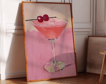 Op de afbeelding: Ingelijste kunstafdruk van een roze cocktail met kersengarnituur. Het schilderij heeft een gestructureerde, impressionistische stijl. Het kunstwerk staat tegen een roze en beige achtergrond met een houten lijst.