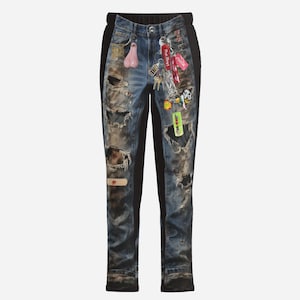 May include: Distressed denim jeans with black side panels. The jeans feature multiple rips and tears, patches, and a collection of keychains and charms. The jeans have a relaxed fit and a drawstring waistband.