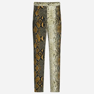 Puede incluir: Pantalones largos con estampado de piel de serpiente. El diseño presenta una mezcla de colores negro, dorado y crema, creando un efecto realista de piel de reptil. Los pantalones tienen un corte recto y un fondo neutro.
