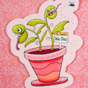 Puede incluir: Una ilustración de dibujos animados de una planta en maceta rosa con dos plantas carnívoras verdes y dentadas con lenguas rojas. La planta tiene un cartel que dice "¡Cuidado Mordemos!"