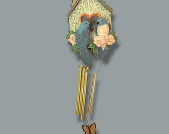 Campana de viento con forma de casita para pájaros con diseño de pájaros azules y mariposas, con tubos dorados y detalles florales, 30 cm de largo.