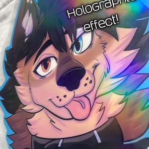 K&ouml;nnte beinhalten: Holografischer Aufkleber mit einem Cartoon-Wolf mit braunem und schwarzem Fell und blauem Hintergrund. Der Wolf hat ein braunes und ein blaues Auge, und seine Zunge h&auml;ngt heraus. Der Aufkleber hat den Text "Holographic effect!" und "SHADOW".