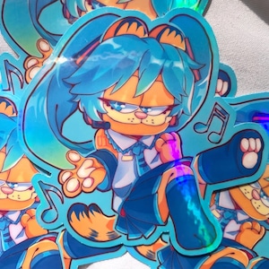 May include: A holographic sticker featuring a cartoon character with blue hair and a blue and white outfit. The character is a combination of a cat and a human, with a grumpy expression. The sticker has a blue and white background with musical notes.