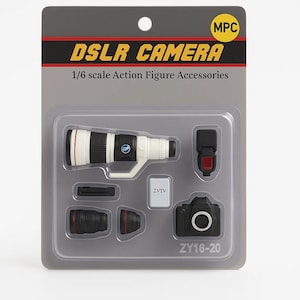 May include: A set of 1/6 scale DSLR camera accessories in a gray plastic package. The set includes a black and white lens, a black camera body, a flash, and other small parts. The package has the text "DSLR CAMERA" and "ZY16-20".