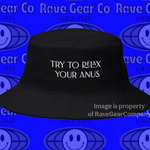 May include: Black bucket hat with the text "TRY TO RELAX YOUR ANUS" in white. The hat is set against a blue background with a repeating pattern of smiley faces and text that reads "Rave Gear Co SINCE 2023".