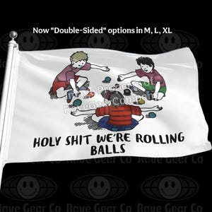 May include: White flag with a cartoon illustration of three children playing with balls. The text "HOLY SHIT WE'RE ROLLING BALLS" is printed in black. The flag also has the text "Now Double-Sided options in M, L, XL".
