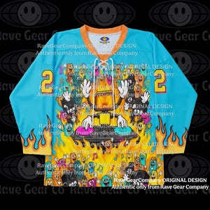 May include: A light blue hockey jersey with orange trim and the number 2 in yellow. The jersey features a colorful cartoon design of a DJ and various characters. The text "Rave Gear Company ORIGINAL DESIGN" is printed on the jersey.