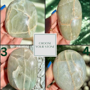 May include: Four polished, oval-shaped stones in shades of green and gray are displayed. Each stone has unique veining patterns. The image includes the text "CHOOSE YOUR STONE".