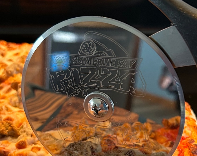 Stainless steel pizza cutter with ergonomic handle. Disc of pizza cutter is engraved
