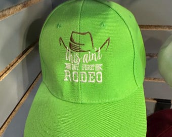 Embroidered This ain't my first Rodeo hat. Green cap with Velcro adjustable strap.