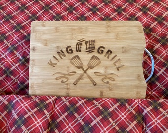 Bamboo engraved cutting board with king of the grill design.