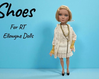 May include: A doll wearing a white crocheted shawl, a white pleated skirt, and black shoes. The doll has blonde hair and is accessorized with a long beaded necklace and yellow gloves. Text on the image reads "Shoes For RT Ellowyne Dolls."