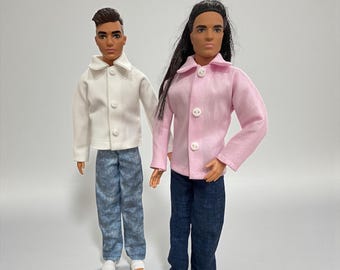Puede incluir: Se muestran dos muñecos de moda, uno con una chaqueta blanca y vaqueros azules, el otro con una chaqueta rosa y vaqueros azul oscuro. Ambos muñecos llevan chaquetas abotonadas y están de pie sobre un fondo liso. Los muñecos llevan zapatos diferentes.