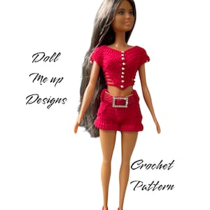 Puede incluir: Un patrón de crochet para un conjunto de top corto y pantalones cortos rojos para una muñeca. El conjunto presenta un detalle de botones blancos y un cinturón de diamantes de imitación.