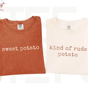 May include: Two crew neck t-shirts, one in burnt orange and one in off-white. The orange shirt features the white text "sweet potato" and the off-white shirt features the brown text "kind of rude potato". Both shirts have a Comfort Colors label.