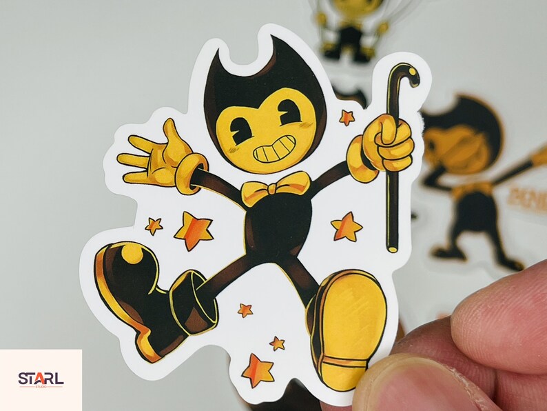 May include: A black and yellow cartoon character with a bow tie and a cane, standing on a white background with yellow stars. The character is from the video game Bendy and the Ink Machine.