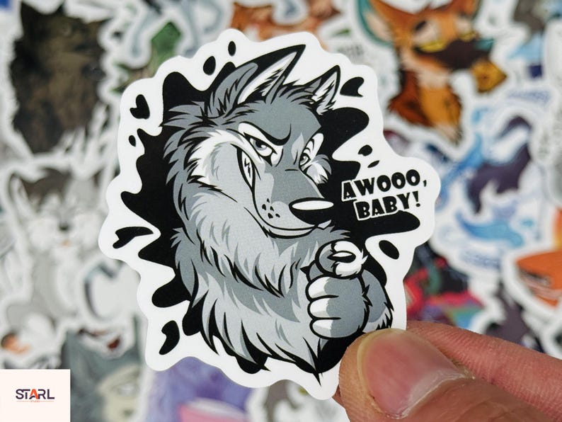 May include: A sticker featuring a cartoon wolf with gray and white fur, a smug expression, and the text "AWOOO, BABY!". The wolf is set against a black and white splash design.